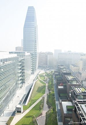 С террасы спальни оформленной квартиры открывается вид на офисные здания и парк, спроектированный итальянской студией LAND